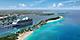 Wide aerial shot of RBC Paradise Island's long stretch of beach with the cruise ship docked near